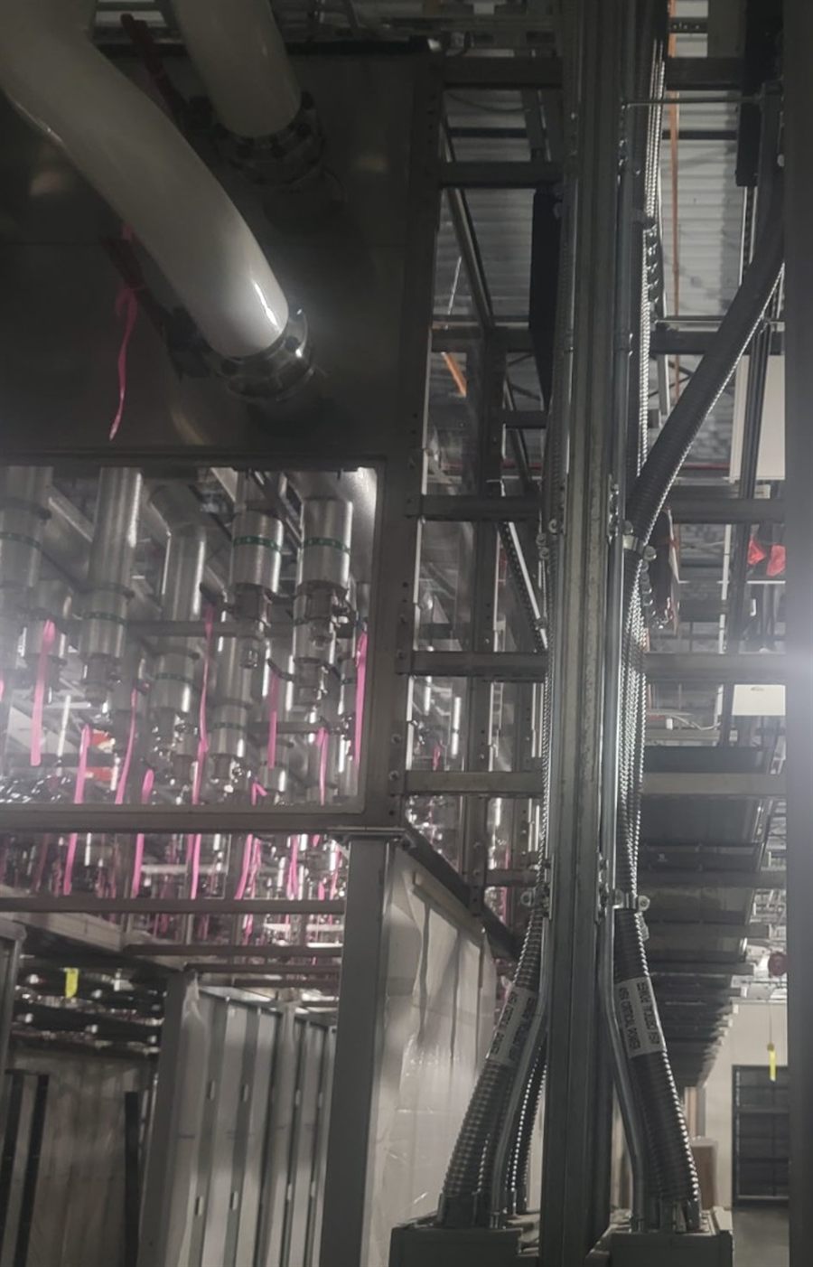 Vertical strut framing carrying labeled power conduit risers
